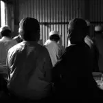 A group of children in traditional attire seated indoors, Bangladesh.